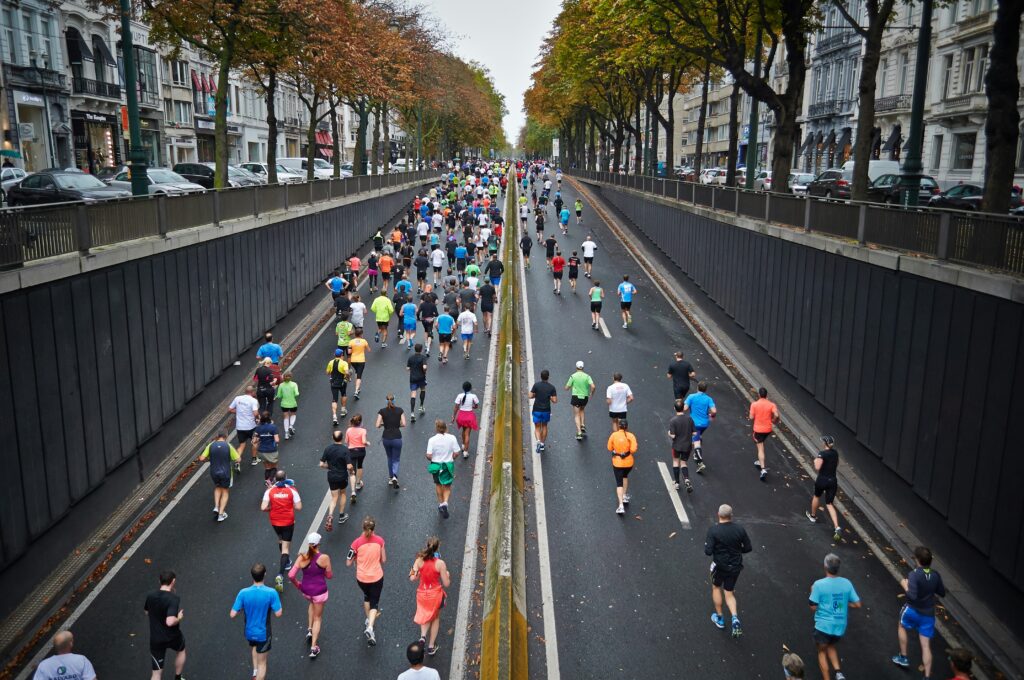 The image depicts several runners emerging from beneath a bridge, suggesting that they are participants in a marathon.